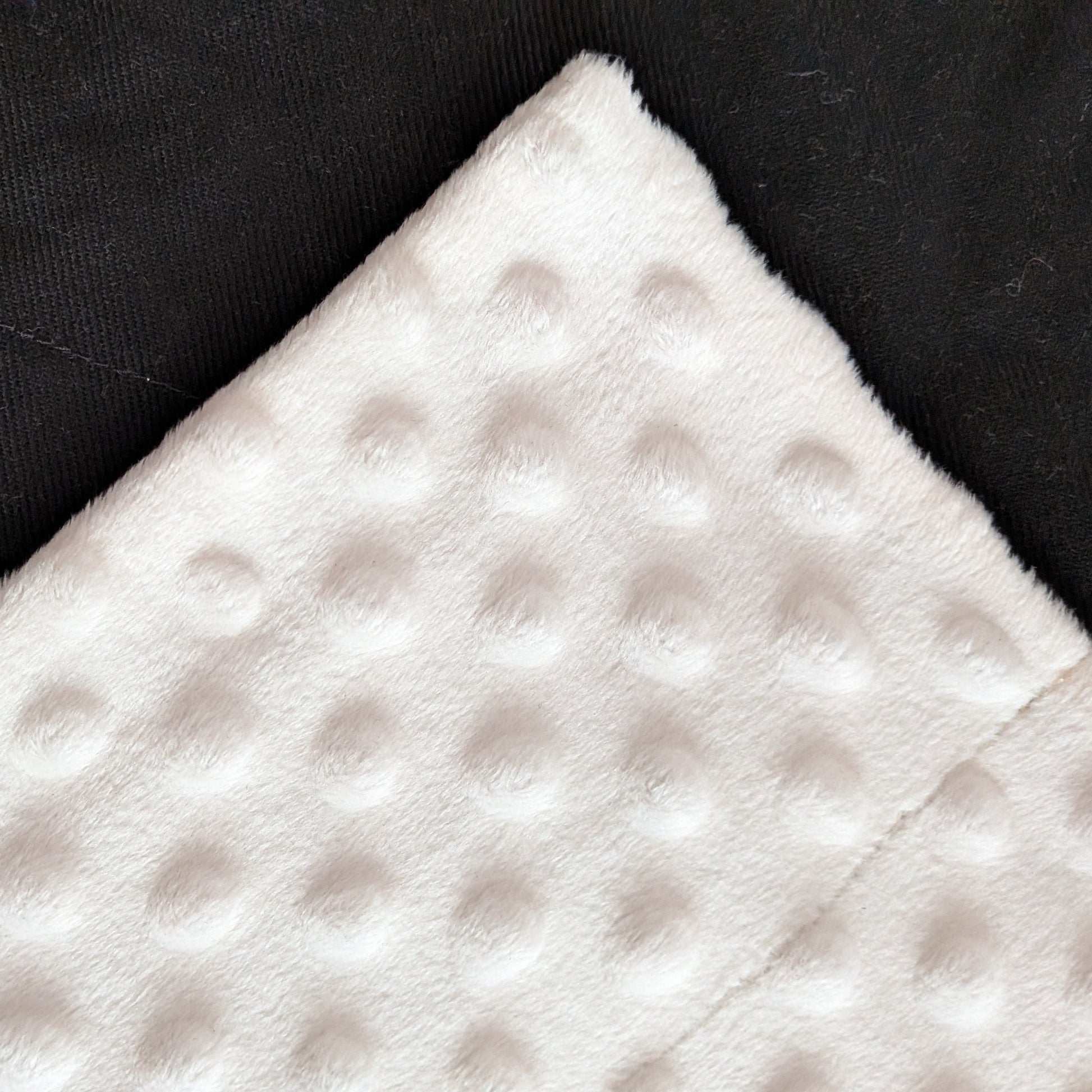 White textured fabric on a black background