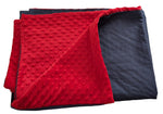 Red and grey textured blankets cover stacked on a light-colored surface
