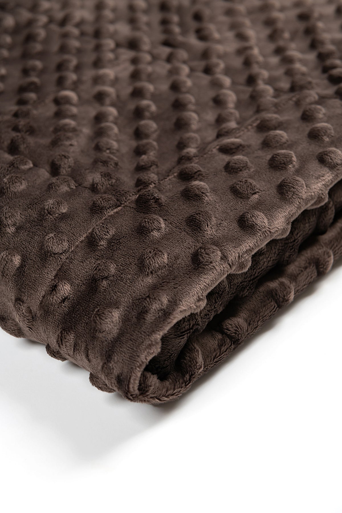 Folded brown textured blanket on a white background