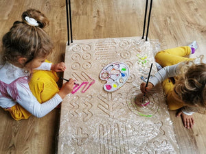 two girls painting good wood sensory platform using paints