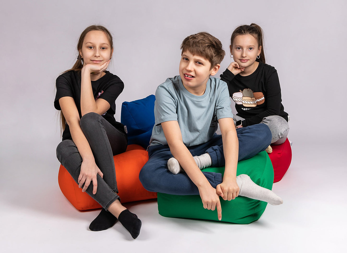 CHILDREN SITTING ON  THE COTTON SQUARE POUFS 